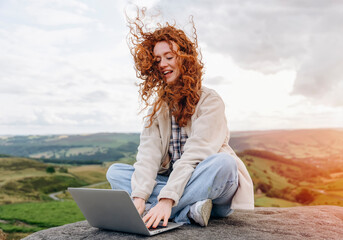 woman traveler and bloger in a white  jacket and backpack traveling mountains in Peak District.  Local tourism lifestyle concept.