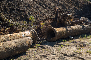 Replacement of city water supply, old rusty pipes among the heaps of earth.
