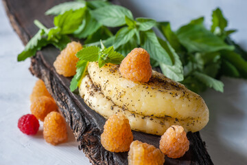 Sliced halloumi cheese with raspberries and strawberries on a wooden board