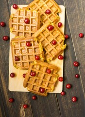 Board with delicious Belgian waffles on wooden background, closeup