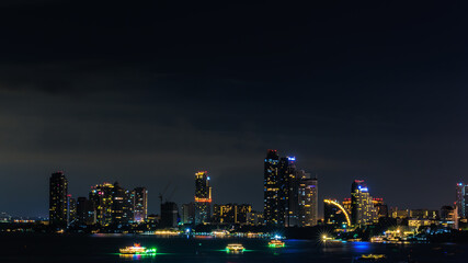Fototapeta na wymiar Cityscape over colors and the lights of pattaya and cruise ships in the sea, pattaya bay at night, Bali Hai View Point,