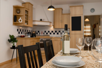 A table is served in the kitchen in the apartment. Wine on the table