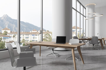 Stylish library interior with shared table and chairs in row, panoramic window