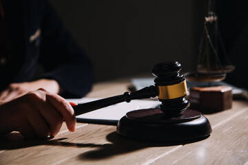 Justice and law concept.Male judge in a courtroom with the gavel, working with, computer and docking keyboard, eyeglasses, on table in morning light