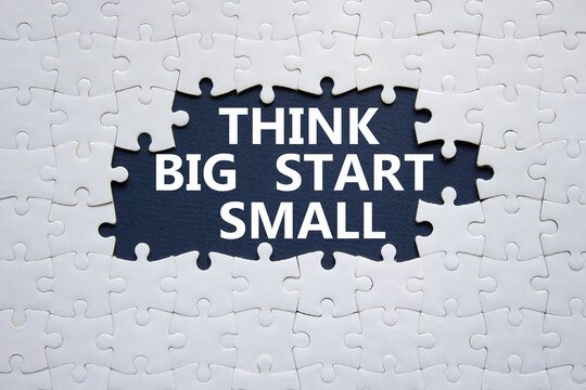 Think big start small symbol. Concept words Think big start small on white puzzle. Beautiful black background. Business and Think big start small concept. Copy space