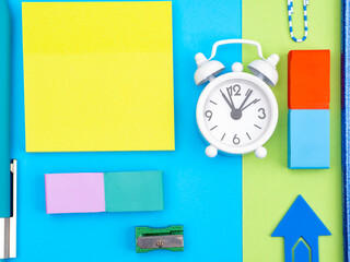 Office desk, stationery and alarm clock, multicolored stickers and note papers as a concept of working in a modern office