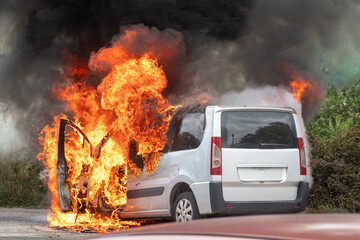 Coche ardiendo en llamas , quemándose y generando humo negro. O coche incendiado
