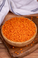 Red lentils on wood background. Raw red lentils in wooden bowl. Close up