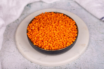 Red lentils on grey background. Raw red lentils in bowl
