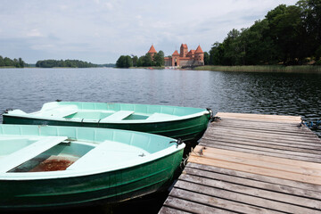 Obraz premium Wooden jetty with boats and on Lake Galve, in the background Trakai Castle Built in the 14th century and served as a residence for the Grand Dukes of Lithuania