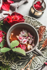 Red rose tea in cup with vintage tea utensils, top view