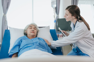 Obraz premium Friendly professional female doctor meeting an elderly patient on a hospital bed the concept of caring for the elderly.