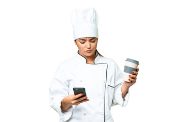 Young woman Chef over isolated chroma key background holding coffee to take away and a mobile