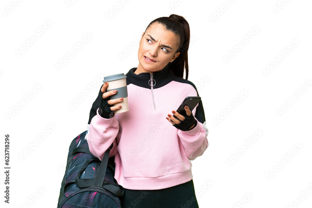 Poster Young sport woman with sport bag over isolated chroma key background holding coffee to take away and a mobile while thinking something