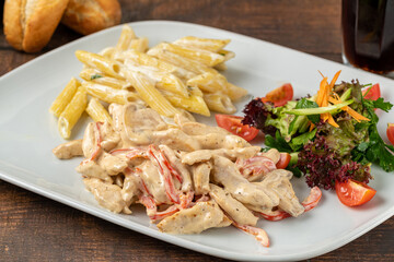 Grilled cubed chicken with pasta and salad