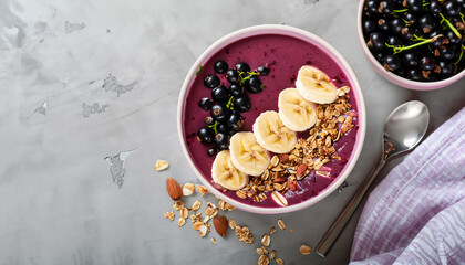Pink black currant berries, banana smoothie bowl with granola, flakes from almonds and chocolate on light gray concrete background. Selective focus. Top view. Copy space.
