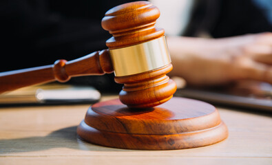 Justice and law concept.Male judge in a courtroom with the gavel, working with, computer and...