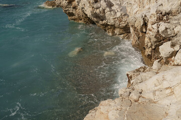 Top down view of sea waves crushing onto rocks