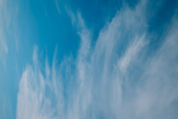 Horizontal photo of white clouds on blue sky.