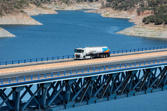 Tanker truck of the Repsol energy company circulating through a viaduct over a swamp.