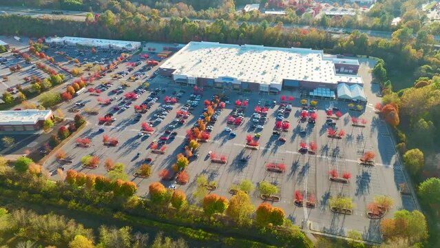 View from above of american grocery store with parked cars on big parking place at sunset in autumnal season. United States food retail