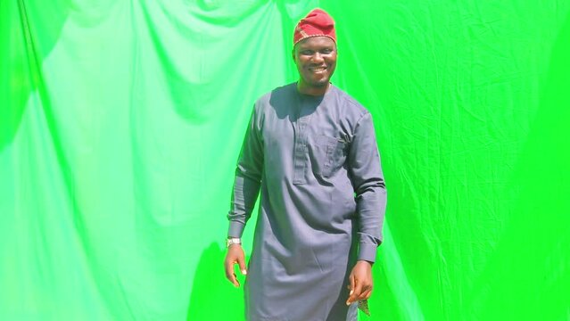 A Yoruba tribesman dressed in traditional attire with a cultural hat posing in a presentation of a model