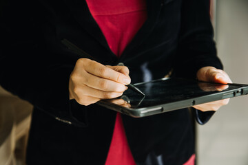 Mature businessman using a digital tablet to discuss information with a younger colleague in a modern business lounge