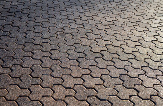 Paver brick floor, brick paving, paving stone or block paving. Manufactured from concrete or stone for road, path, driveway and patio. Empty floor in perspective view selective focus