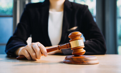 Justice and law concept.Male judge in a courtroom with the gavel, working with, computer and docking keyboard, eyeglasses, on table in morning light