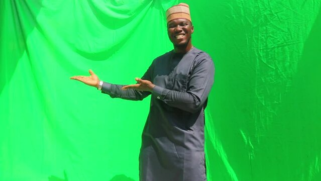 Matured male elaborately present a product to the left and right with a green screen background for marketing television or social media advert