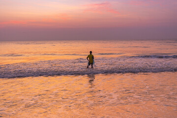 Fototapeta na wymiar A young Fisherman prepares on cast the sunrise in Thailand.