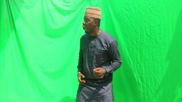 Nigerian man from the north demonstrated excitement as 3d objects marketing objects fall from the sky in front of green screen