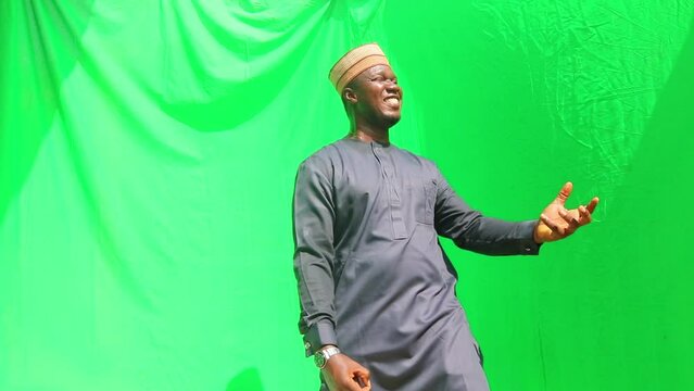Cheerful Nigerian adult male plays air guitar in celebration of win in a happiness advertisement