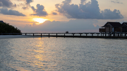 Fototapeta premium A COUPLE IN A WONDERFUL VIEW OF THE MALDIVIAN SUNSET 
