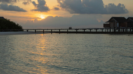 Fototapeta na wymiar A COUPLE IN A WONDERFUL VIEW OF THE MALDIVIAN SUNSET 
