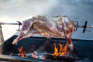 spit barbeque in the backyard with a lamb above the charcoal © poco_bw