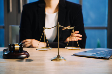 Justice and law concept.Male judge in a courtroom with the gavel, working with, computer and docking keyboard, eyeglasses, on table in morning light