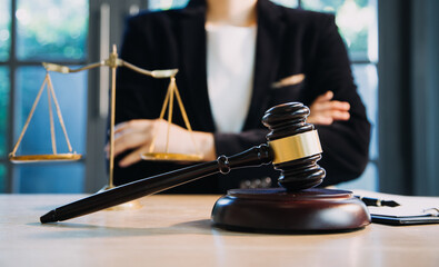 Justice and law concept.Male judge in a courtroom with the gavel, working with, computer and docking keyboard, eyeglasses, on table in morning light