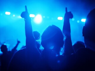Silhouette of people attengding a concert with raising hands