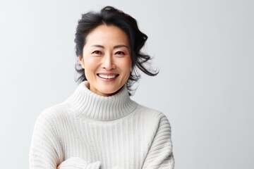 Fototapeta premium Portrait of a smiling asian woman in sweater on white background