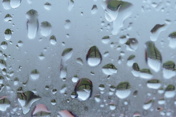 Raindrops on the window. Water falling on the glass. natural background, freshness. Cold rainy weather. Close-up.