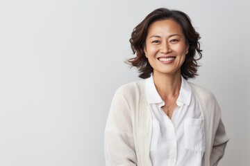 Portrait of a smiling asian businesswoman standing against white background