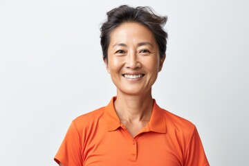 Portrait photography of a pleased Chinese woman in her 50s wearing a sporty polo shirt against a white background 