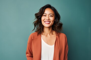 Fototapeta premium Portrait photography of a pleased Chinese woman in her 30s wearing a chic cardigan against an abstract background 