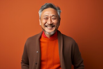 Obraz premium Portrait photography of a cheerful Chinese man in his 50s wearing a chic cardigan against an abstract background 