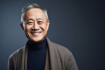 Fototapeta premium Portrait photography of a cheerful Chinese man in his 50s wearing a chic cardigan against an abstract background 