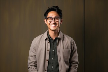 Fototapeta premium Portrait photography of a pleased Indonesian man in his 30s wearing a chic cardigan against an abstract background 
