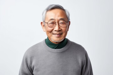 Portrait of Asian senior man in grey sweater on white background.