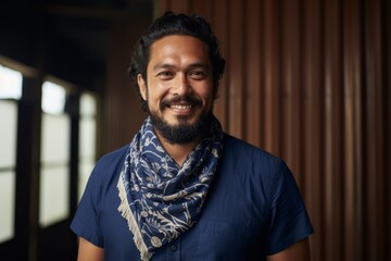 Obraz premium Portrait photography of a satisfied Indonesian man in his 30s wearing a foulard against an abstract background 