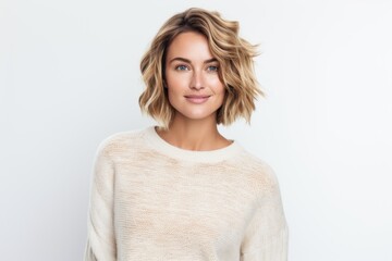 portrait of beautiful blonde woman in sweater looking at camera isolated on white